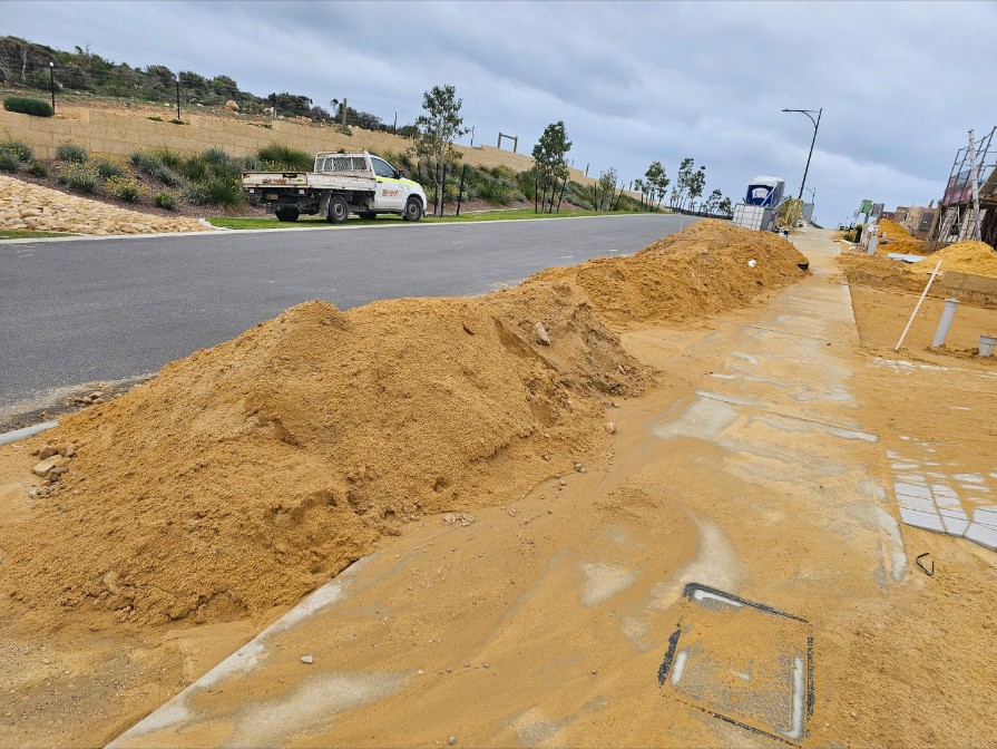 Street verge with piled sand before clean-up